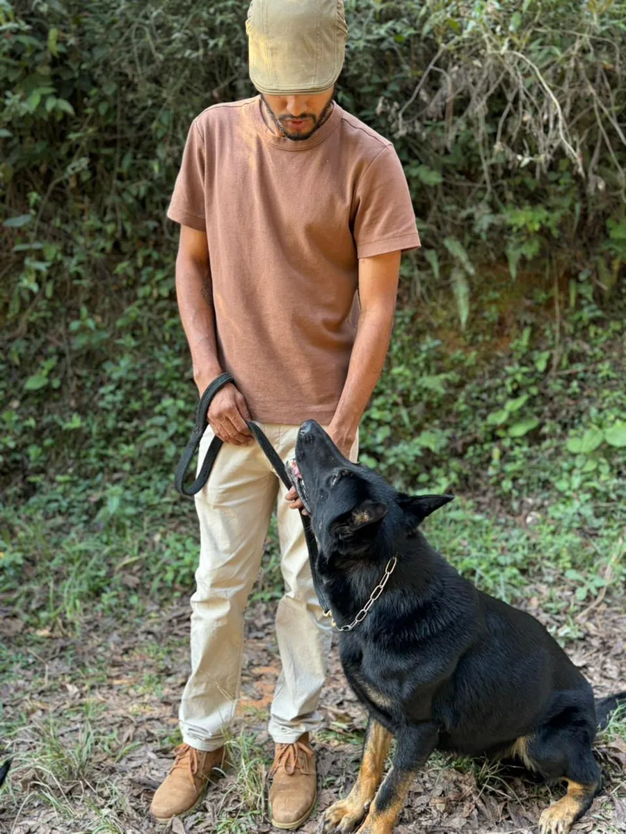 Eduardo conduzindo um cão durante sessão de educação canina